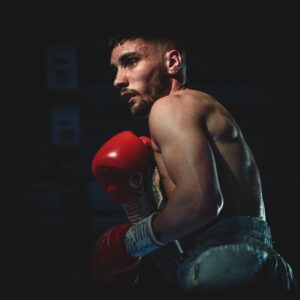 Boxer performing a shell-guard, while wearing boxing gloves