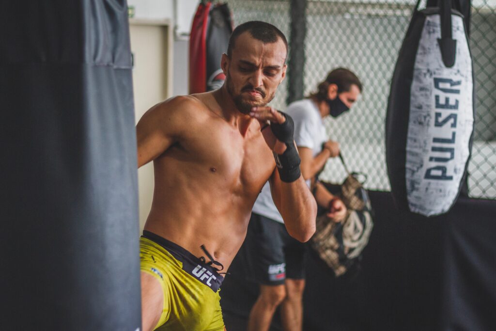 MMA fighter inside a fighting gym, doing heavy bag work